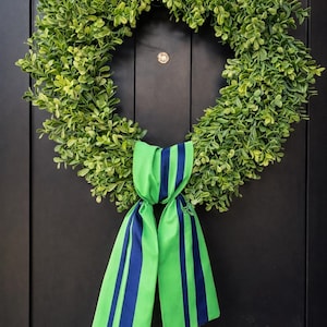 May include: A white ceramic mug with a black handle and the text "But First, Coffee" in a bold, black font. The mug is filled with a dark liquid, likely coffee, and sits on a light-colored surface.