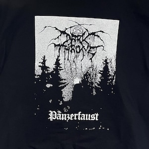 Może przedstawiać: Czarny t-shirt z białym nadrukiem przedstawiającym leśną scenerię, słowa "Darkthrone" i "Panzerfaust" gotycką czcionką. Projekt zawiera pentagram i mroczną, klimatyczną estetykę.