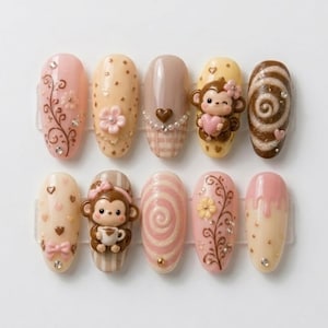 Könnte beinhalten: Ein Set aus zehn künstlichen Nägeln mit verschiedenen Designs. Die Nägel weisen eine Reihe von Farben auf, darunter Rosa, Beige und Braun, und sind mit floralen Mustern, Herzen und Affenfiguren verziert. Einige Nägel haben ein Wirbeldesign.