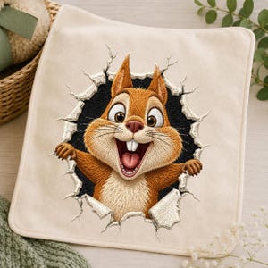 May include: A square off-white fabric piece featuring a detailed machine embroidery design of a brown squirrel appearing to burst through a dark hole. The squirrel has large eyes, a wide open mouth with visible teeth, and paws reaching outward.
