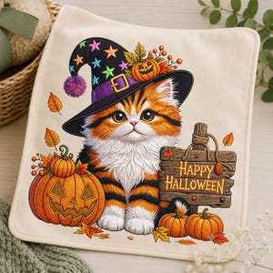 May include: A square off-white fabric piece featuring an embroidered orange and black tabby kitten wearing a black witch hat with colorful stars. The design includes three orange pumpkins and a wooden sign with the text Happy Halloween.
