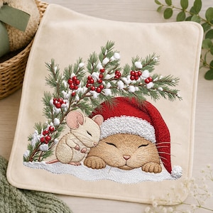 May include: A square cream-colored fabric piece featuring an embroidered design of a small tan mouse resting against a sleeping tan cat wearing a red Santa hat. Above them are green pine branches with red berries and white snow accents on a white base.