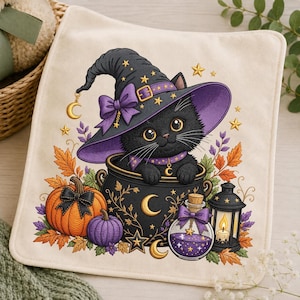 May include: A square off-white fabric piece featuring a black kitten wearing a purple witch hat with a gold buckle and bow. The kitten sits in a black cauldron surrounded by an orange pumpkin, a purple pumpkin, a lantern, and a potion bottle.