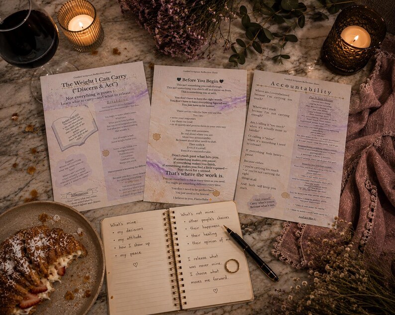 Peut inclure: Vue a&eacute;rienne de trois pages imprim&eacute;es avec de la po&eacute;sie, un carnet avec des notes manuscrites, un stylo et une bague. Une assiette avec une p&acirc;tisserie, deux bougies allum&eacute;es et un verre de vin sont &eacute;galement visibles. Les pages ont du texte qui dit "The Weight I Can Carry", "Before You Begin", et "Accountability".