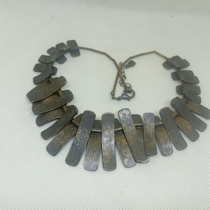 Puede incluir: Un juego de tres tazas de cerámica con un acabado mate moteado. Las tazas son de color crema, gris claro y gris oscuro. Cada taza tiene un diseño simple y minimalista y un asa redondeada.