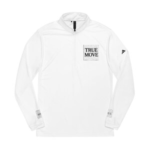 Peut inclure: Haut de sport blanc à manches longues avec un col zippé. Le t-shirt porte l'inscription "TRUE MOVE" dans un carré sur la poitrine et un petit logo sur la manche. Idéal pour le sport.