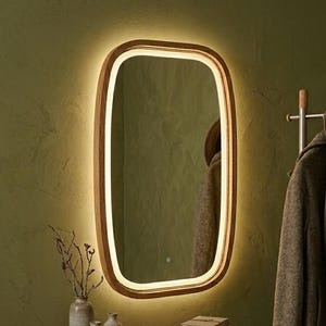 May include: A rectangular wall mirror with rounded corners and a light wood frame. The mirror features an integrated LED light strip along the inner edge, emitting a warm glow. A small touch-sensitive power icon is visible on the glass surface.