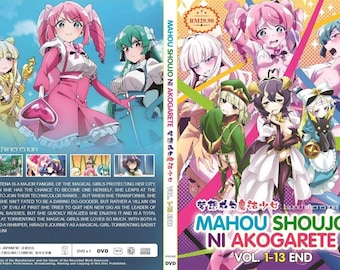 Puede incluir: Caja de DVD de "Mahou Shoujo Ni Akogarete Vol. 1-13 End" con ilustraciones de estilo anime de chicas mágicas. La portada tiene un esquema de color rosa y azul con texto japonés y el título. La parte posterior tiene un resumen de la trama.
