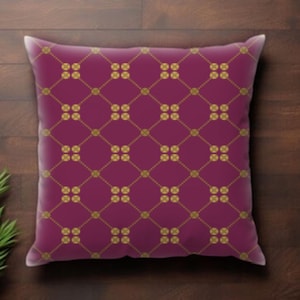 May include: A decorative square pillow with a deep magenta background. The pillow features a repeating pattern of gold-colored linked circles and lines, creating a diamond grid design. The pillow is placed on a dark wood surface.