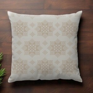 May include: A square throw pillow featuring a light cream background with a repeating geometric pattern of tan, pixelated star-like shapes. The design consists of small dots arranged in symmetrical clusters across the entire surface of the pillow.