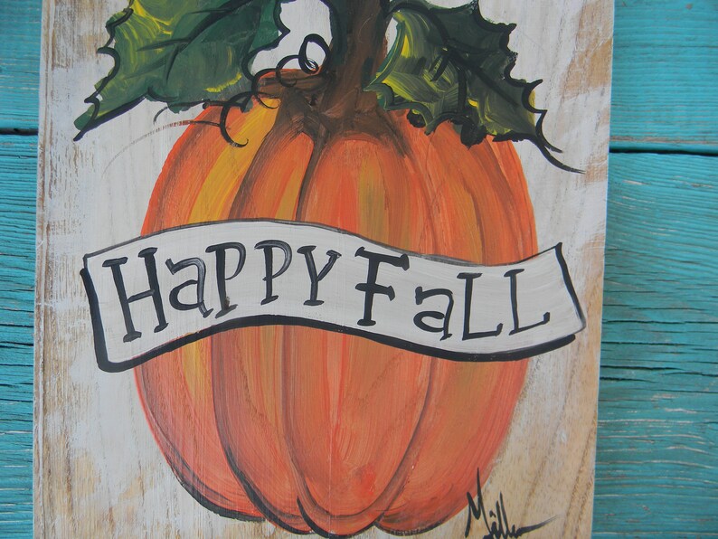 May include: A hand-painted wooden sign with a large orange pumpkin and a white banner that reads "Happy Fall".