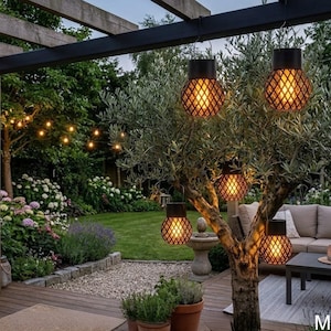 May include: Outdoor scene featuring decorative hanging lanterns with a diamond pattern, emitting a warm glow. The lanterns are suspended from a black pergola and tree branches. The scene includes a lush green garden, a wooden deck, and a seating area.