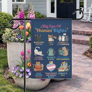 May include: A navy blue garden flag with the text "Big Fan Of Human Rights" and various cat illustrations. The flag includes phrases such as "Black Lives Matter," "Love is Love," and "Trans Rights are Human Rights."