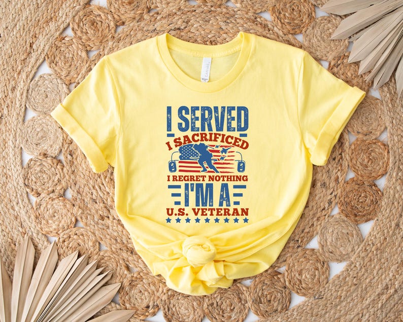 May include: A yellow t-shirt with the text "I SERVED I SACRIFICED I REGRET NOTHING I'M A U.S. VETERAN" in blue and red. The design includes an American flag and a silhouette of a soldier. The shirt is folded.