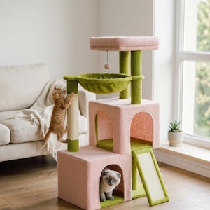 May include: A pink and green cat tree with multiple levels, a scratching post, and a ramp. Two cats are interacting with the cat tree. One cat is climbing the scratching post, and the other is inside the cat tree.