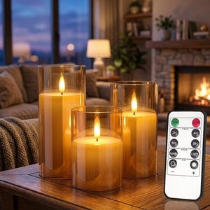 May include: Three cylindrical LED candles in amber-tinted glass sleeves, each featuring a warm glowing flame effect. A white rectangular remote control with buttons for power, timer settings, light modes, and brightness levels is positioned nearby.