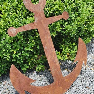 Könnte beinhalten: Handgefertigtes Holzschild mit dem Wort "Willkommen" in verspielter Schrift. Das Schild ist weiß lackiert mit einem Used-Look und zeigt ein Blumendesign in Rosa- und Grüntönen. Es ist etwa 30 cm breit.