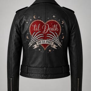 Puede incluir: Una chaqueta de moto de cuero negro con un diseño bordado en la espalda de un corazón rojo sostenido por dos manos esqueléticas. El texto 'til Death' está bordado sobre el corazón y 'DO US PART' en una cinta debajo, rodeado de estrellas y lunas.