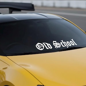 May include: A yellow sports car with a black roof and spoiler. The windshield displays the white text "Old School" in a gothic font, creating a vintage aesthetic. The car's design suggests a focus on performance and style.