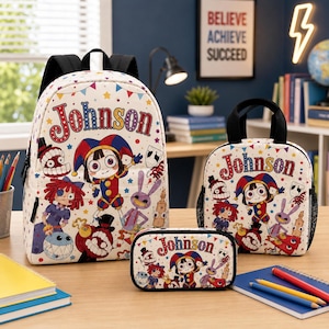 Puede incluir: Un conjunto de mochila, bolsa de almuerzo y estuche blancos con un estampado de dibujos animados de varios personajes, incluido un bufón, y el nombre Johnson en letras rojas. Los artículos tienen correas y bordes negros con estrellas.