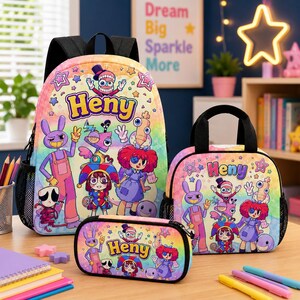 Puede incluir: Un conjunto de mochila, bolsa de almuerzo y estuche con un fondo de degradado arcoíris, personajes de dibujos animados y el nombre Heny impreso en morado. Cada artículo incluye correas negras y bolsillos laterales de malla.