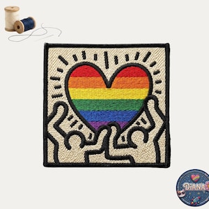 May include: Embroidered patch featuring a rainbow heart design, framed by a black border and stylized figures. The heart is filled with the colors of the rainbow. The patch is square-shaped and has a beige background.