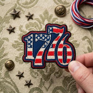 May include: An embroidered patch featuring the number 176 with a red, white, and blue American flag pattern. The patch has a thick black border and is shaped to follow the contours of the digits. The design includes white stars on a blue field.