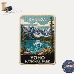 May include: A rectangular embroidered patch featuring a landscape of Yoho National Park in Canada, with snow-capped mountains, a turquoise lake, and pine trees. The text reads CANADA at the top and YOHO NATIONAL PARK at the bottom. Two spools of thread are nearby.