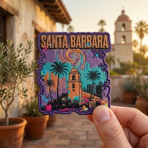 May include: A rectangular embroidered patch featuring the text SANTA BARBARA in tan letters. The design depicts a mission-style building, palm trees, and a swirling sky in shades of purple, teal, orange, and black with a scalloped border.