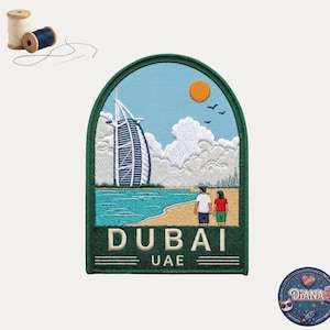 May include: An embroidered patch featuring the Burj Al Arab hotel in Dubai, UAE, with a beach scene, two people, a blue sky, an orange sun, and white clouds. The patch has a dark green border and the text DUBAI UAE at the bottom.