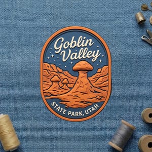 May include: An oval-shaped patch featuring a dark blue background with a desert landscape of orange rock formations and the text Goblin Valley STATE PARK, UTAH in white lettering, accented by small white stars against the night sky.