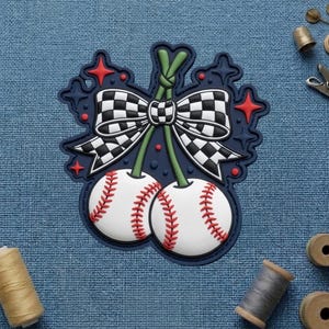 May include: A baseball-themed design featuring two baseballs with red stitching, connected by green stems and a checkered bow. The design is outlined in navy blue with red star accents, set against a blue fabric background.