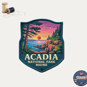 May include: A shield-shaped embroidered patch featuring a landscape of Acadia National Park in Maine. The design shows a sunset over a rocky coastline with pine trees, blue water, and pink clouds. The text reads ACADIA NATIONAL PARK MAINE.