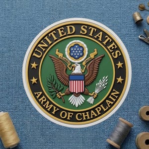 May include: A circular emblem featuring the words "UNITED STATES ARMY OF CHAPLAIN" in a black and gold border. The emblem includes an eagle, stars, and the words "E PLURIBUS UNUM". The background is a textured blue fabric.
