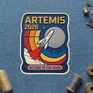 May include: A rectangular patch with a space theme. The patch features a rocket launching towards a gray moon, with the text "ARTEMIS 2026" and "RETURN TO THE MOON". The design includes a colorful retro-style arc and stars.
