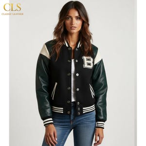 Può includere: Giacca college nera con maniche in pelle verde, colletto bianco e toppa "B" bianca. La giacca ha polsini e orlo a righe bianche e nere. Il logo "CLS CLASSIC LEATHER" si trova nell'angolo in alto a sinistra.