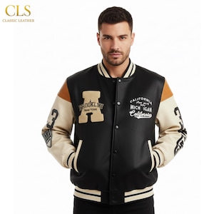 Puede incluir: Chaqueta universitaria negra y beige con el texto "BROOKLYN NEW YORK" y "CALIFORNIA MICHIGAN California". La chaqueta tiene mangas blancas y beige, un cuerpo negro y el número "3" en la manga.