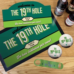 May include: A green and white sign and mat set with the text "Welcome to The 19th Hole, Dad's Pub". Includes golf balls and a bottle opener with the same logo. Beer bottles are visible in the background.