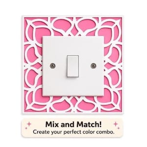 May include: A white light switch with a silver toggle is set against a pink backdrop with a white, ornate, cutout design. The text "Mix and Match! Create your perfect colour combo." is below the switch.
