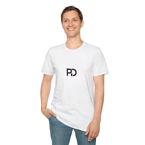 Puede incluir: Camiseta blanca de cuello redondo con las letras negras "PD" impresas en la parte delantera. La persona lleva vaqueros azules. La camiseta está hecha de un material suave y cómodo.
