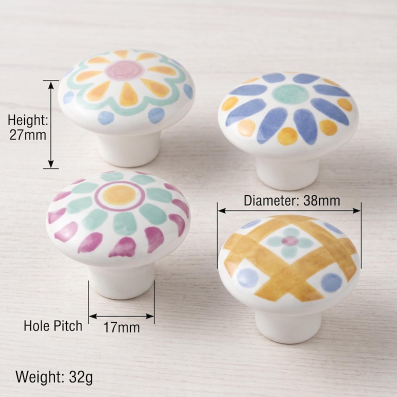 May include: Four round ceramic knobs with hand-painted floral and geometric patterns in yellow, blue, pink, and green. Each knob has a height of 27mm, a diameter of 38mm, a hole pitch of 17mm, and a weight of 32g, as indicated by the text labels.