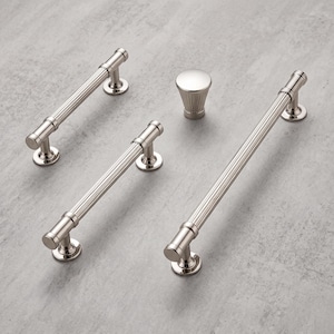 May include: A collection of polished nickel cabinet hardware including two short drawer pulls, one long drawer pull, and one matching round cabinet knob. Each piece features a fluted, cylindrical design with smooth, circular mounting bases.