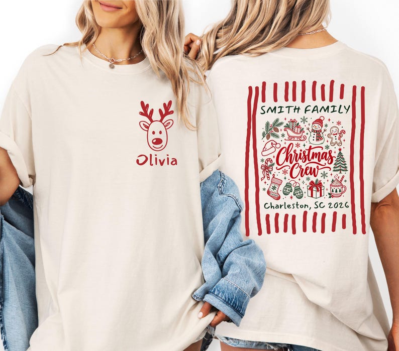 May include: A cream-colored t-shirt featuring a red reindeer graphic and the name Olivia on the front. The back displays a red-striped border containing Christmas icons, the text Smith Family, Christmas Crew, and Charleston, SC 2026.