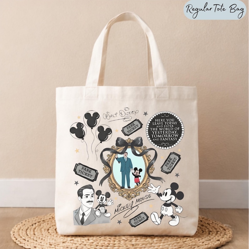 May include: A cream-colored canvas tote bag featuring a graphic print of Walt Disney, Mickey Mouse, park tickets, and balloons. The design includes a central ornate frame with a black bow, and text that reads: Here you leave today and enter the world of yesterday, tomorrow and fantasy.