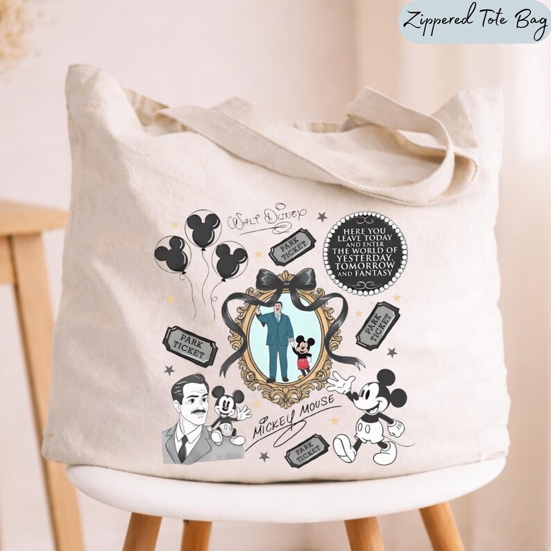 May include: A cream-colored canvas tote bag featuring a black and gold graphic print. The design includes illustrations of Mickey Mouse, Walt Disney, park tickets, balloons, and a circular plaque with the text Here You Leave Today And Enter The World Of Yesterday, Tomorrow And Fantasy.