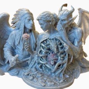 May include: A light gray resin sculpture featuring three figures: a winged person in a feathered headdress holding a rose, a central figure with an exposed ribcage containing a heart, and a winged demon whispering into the central figure's ear.