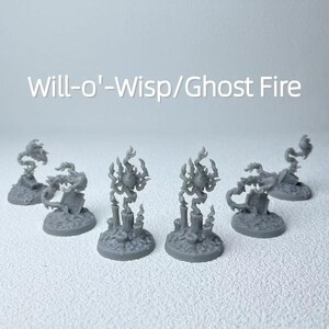 May include: Several gray miniature figurines of Will-o'-Wisps/Ghost Fire. The figurines have a flame-like design and are set on small, round bases. The text "Will-o'-Wisp/Ghost Fire" is displayed in white letters.