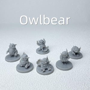 Puede incluir: Una colecci&oacute;n de seis figuras en miniatura grises de Owlbeast, cada una sobre una base circular. Las figuras var&iacute;an en pose, algunas de pie, sentadas o sosteniendo objetos. La palabra "Owlbear" est&aacute; escrita en blanco en la parte superior.