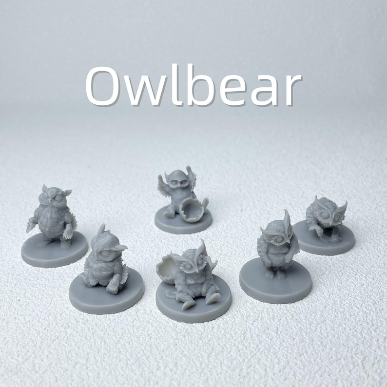Puede incluir: Una colecci&oacute;n de seis figuras en miniatura grises de Owlbeast, cada una sobre una base circular. Las figuras var&iacute;an en pose, algunas de pie, sentadas o sosteniendo objetos. La palabra "Owlbear" est&aacute; escrita en blanco en la parte superior.