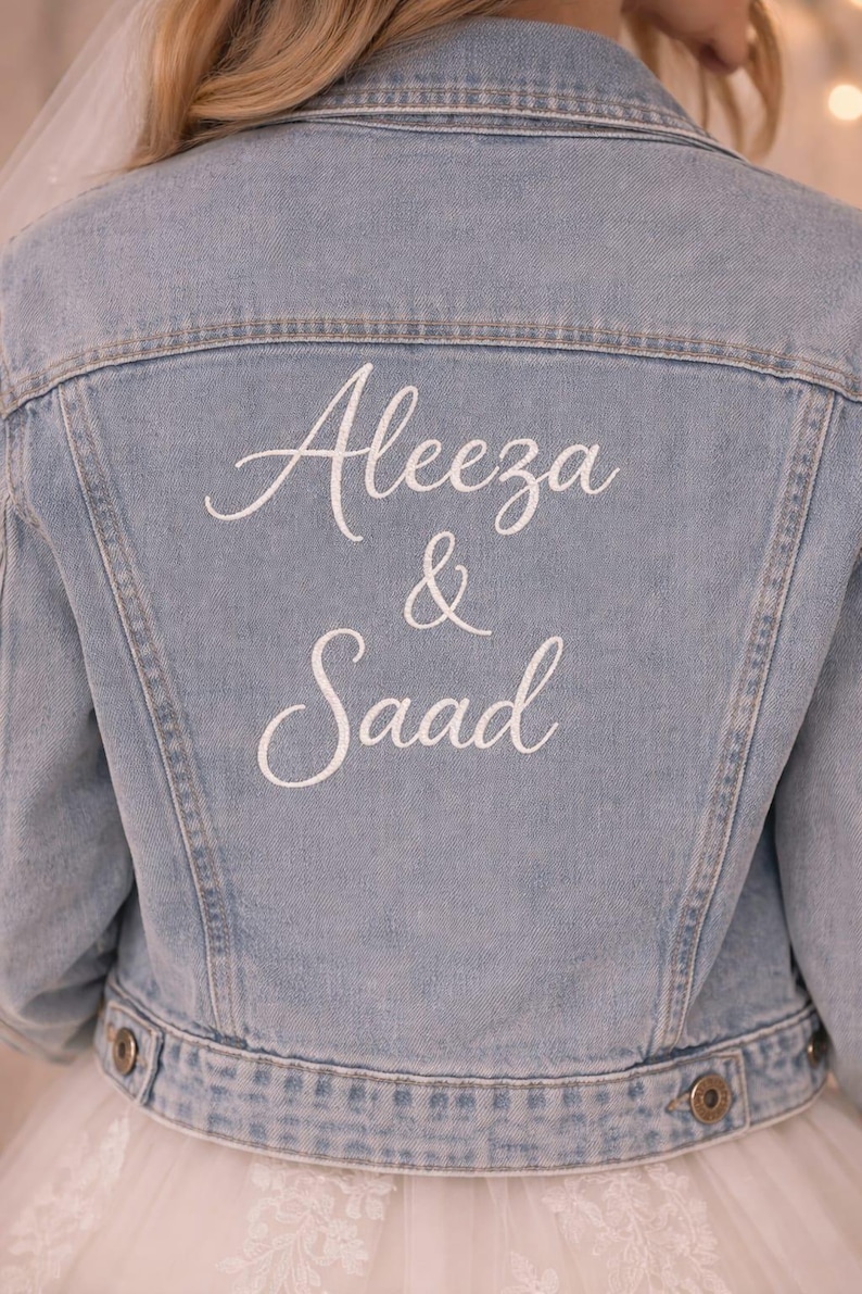 May include: Pale blue denim jacket featuring the embroidered names "Aleeza & Saad" in white script on the back. The jacket has a traditional design with button fastenings. Bridal wear.